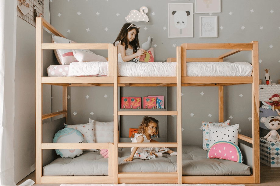 Criança brincando com brinquedos na cama Bododo